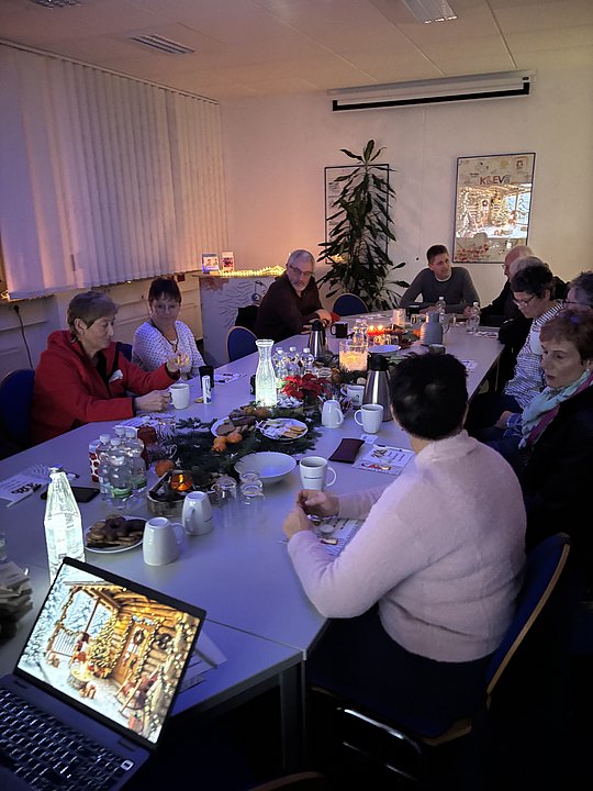 Menschen sitzen am Adventstisch und unterhalten sich