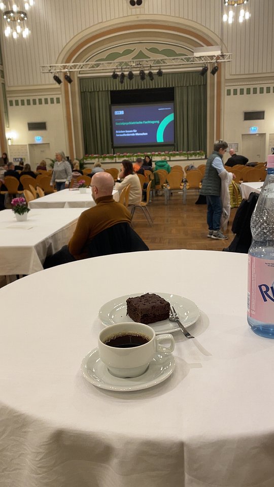 Saal der gesamten Veranstaltug. Kaffeetasse im Vordergrund