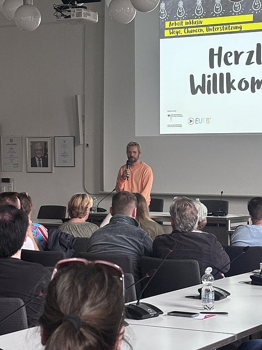 Menschen sitzen und hören dem Vortrag von der Deutschen Rentenversicherung zu