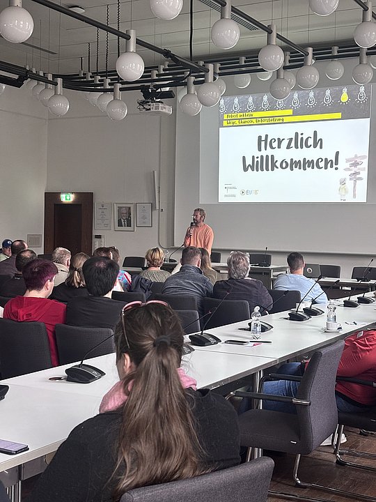 Menschen sitzen und hören dem Vortrag von der Deutschen Rentenversicherung zu