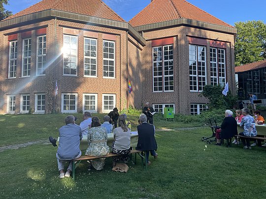 Sitzende Personen mit dem Gocher Kastell im Hintergrund