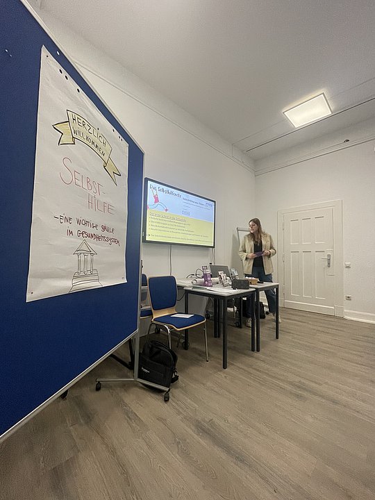 Stellwand des Workshops im Vordergrund, Franziska Rütjes im Hintergrund