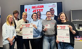 Personen aus dem Netzwerk halten das Plakat zum Aktionstag