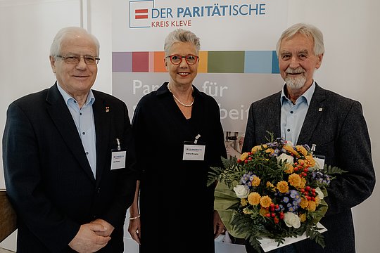 Bernd Wessels mit Blumenstrauß. gemeinsam mit Frau Büngeler und Herrn Wolter