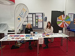Ein Infostand hinter dem zwei Frauen stehen
